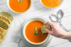 dipping-almond-flour-bread-into-healthy-roasted-tomato-soup