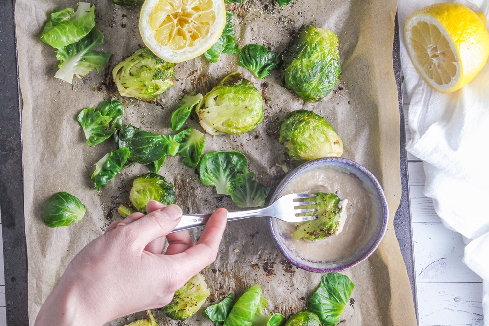 Smashed-brussels-sprouts-being-dipped-in-tahini